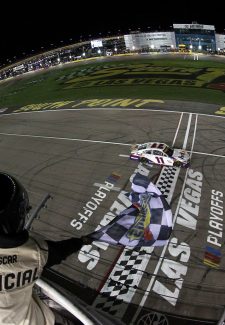 LAS VEGAS, NEVADA - SEPTEMBER 26: Denny Hamlin, driver of the #11 FedEx Office Toyota, takes the checkered flag to win the NASCAR Cup Series South Point 400 at Las Vegas Motor Speedway on September 26, 2021 in Las Vegas, Nevada. (Photo by Meg Oliphant/Getty Images)